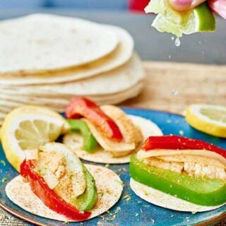 Sizzling, spicy chicken, with crunchy bell peppers, caramelized onions, and rice and refried beans, piled inside a flour or corn tortilla! www.showmetheyummy.com #mexican #tortilla #chicken #fajitas #veggies #dinner #spicy