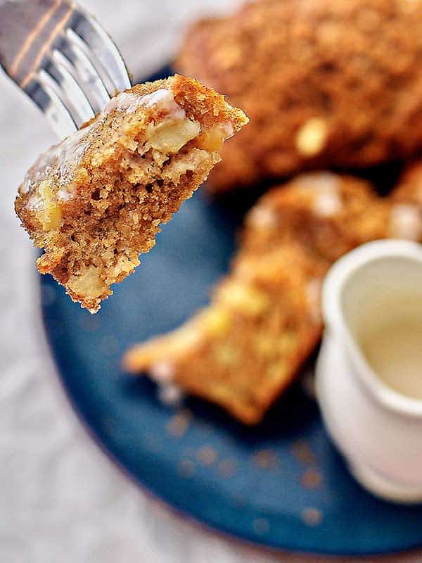 bite being picked up with fork of apple cake loaf above plate