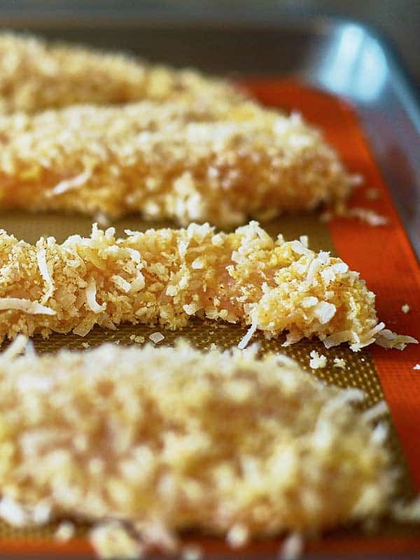 coconut chicken fingers on baking sheet