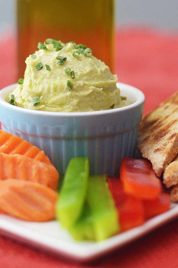 bowl of jalapeno hummus on plate with veggies and pita