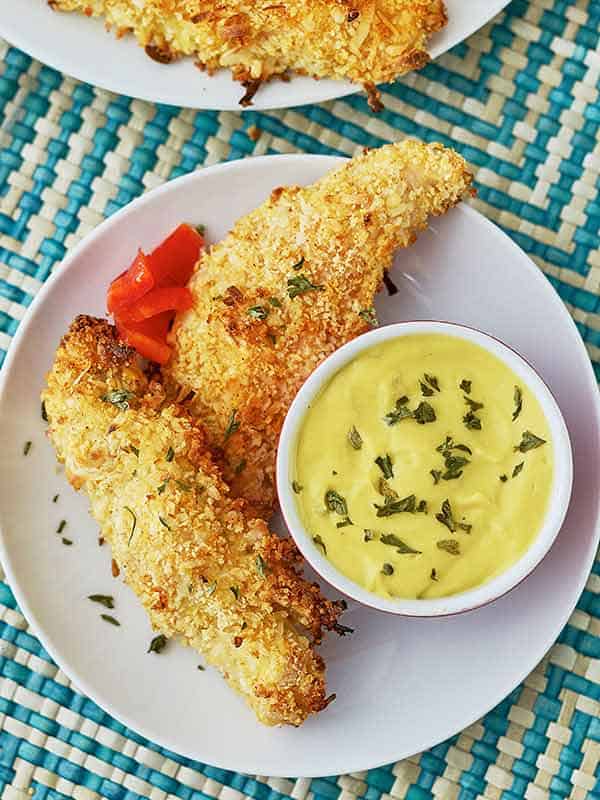 coconut chicken fingers on plate with dip above