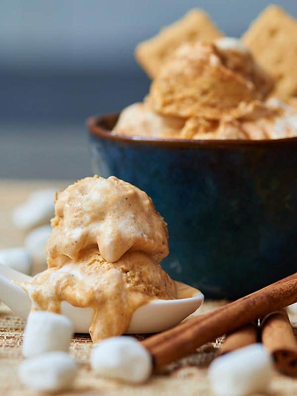 spoonful of pumpkin ice cream with mini marshmallows, bowl in background