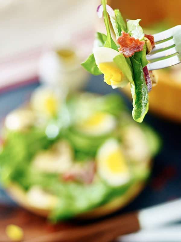 forkful of warm bacon spinach salad