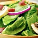 Crispy bacon, hard boiled egg, crunchy red onion, meaty mushrooms, and tender spinach. All smothered in a warm creamy bacon dressing. This warm bacon spinach salad is a must on a cold, fall day! #salad #healthy #bacon #bacondressing #mushrooms #redonion www.showmetheyummy.com