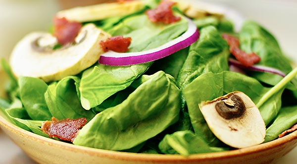 Crispy bacon, hard boiled egg, crunchy red onion, meaty mushrooms, and tender spinach. All smothered in a warm creamy bacon dressing. This warm bacon spinach salad is a must on a cold, fall day! #salad #healthy #bacon #bacondressing #mushrooms #redonion www.showmetheyummy.com