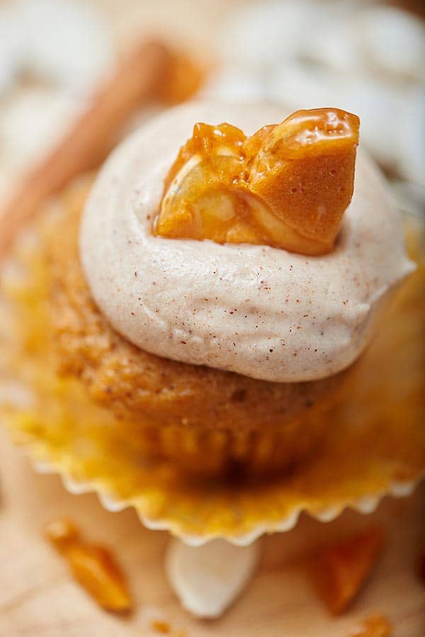pumpkin cupcake with frosting and piece of brittle on top above