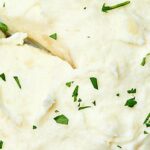 These roasted garlic and goat cheese mashed potatoes are perfectly lump free, super garlicky and toasty, and so so SO creamy from the butter, sour cream, and cream cheese. The goat cheese adds just the right amount of tang to round the whole thing out! showmetheyummy.com #sidedish #vegetarian #mashedpotatoes #goatcheese #holiday
