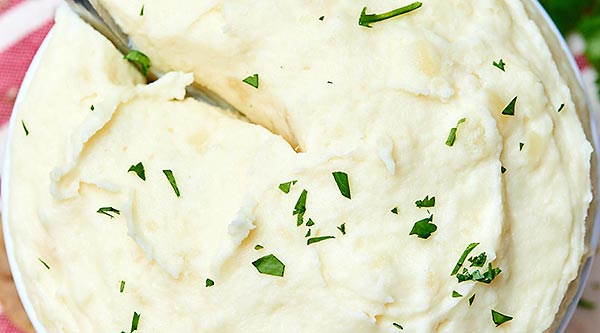 These roasted garlic and goat cheese mashed potatoes are perfectly lump free, super garlicky and toasty, and so so SO creamy from the butter, sour cream, and cream cheese. The goat cheese adds just the right amount of tang to round the whole thing out! showmetheyummy.com #sidedish #vegetarian #mashedpotatoes #goatcheese #holiday
