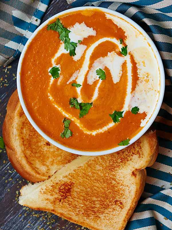 So long canned soup! This roasted tomato soup, is so good and fast to put together. I love how roasting the tomato, onions, and garlic brings out sooo much flavor. The tomato flavor is subtle and bright, and it's so creamy and thick without needing much butter at all! Can we vegetarian and vegan friendly! showmetheyummy.com #soup #roastedvegetables #tomato #meatless #vegetarian #vegan #roastedtomatosoup