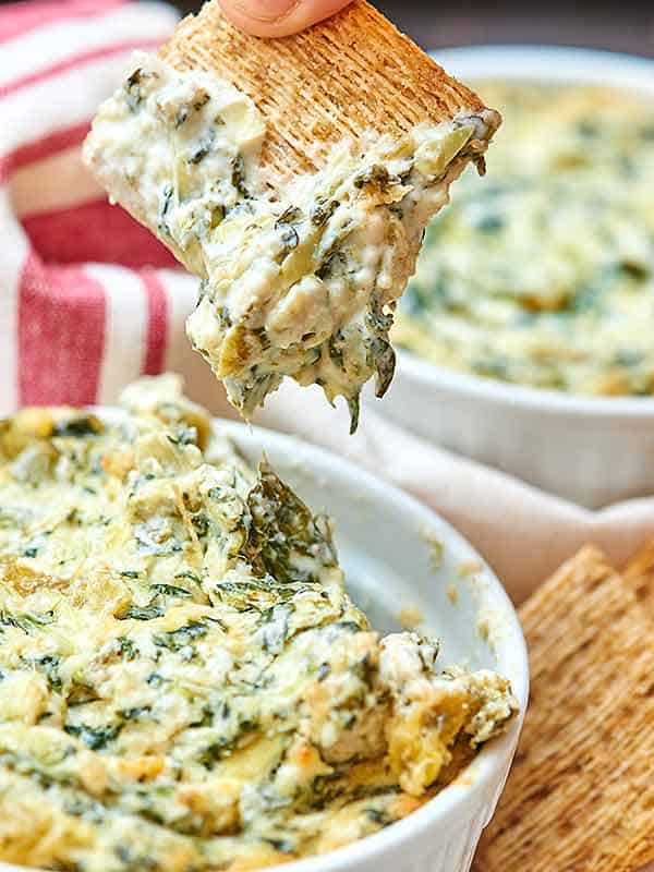 This spicy spinach artichoke dip is hot, creamy, spicy, overall full of flavor, and you get some veggies in, too! Don't be alarmed if you see someone licking the bottom of the bowl...that's totally normal...at least in our house. ;) showmetheyummy.com #appetizer #vegetarian #holiday #dips