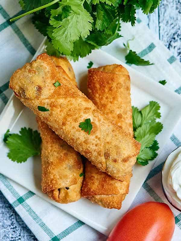 Three egg rolls on plate above