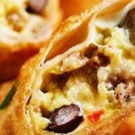 These breakfast egg rolls can be a fun change to your breakfast routine! The outside is perfectly crunchy and is filled with creamy eggs, gooey cheese, slightly crunchy veggies, salty sausage, and yummy black beans! It's hearty, it's delicious, and you're going to be hooked after one bite! showmetheyummy.com #eggrolls #breakfast #eggs #vegetables #sausage #fried