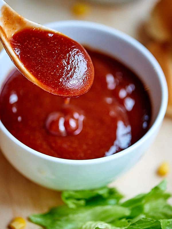 bowl of bbq sauce, spoon held above