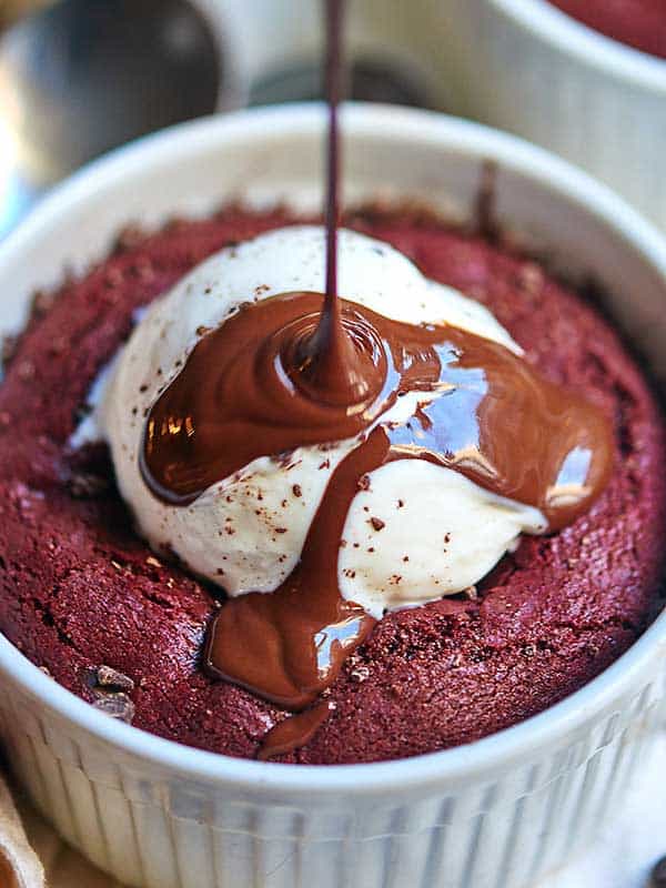 deep dish red velvet cookie being drizzled with chocolate