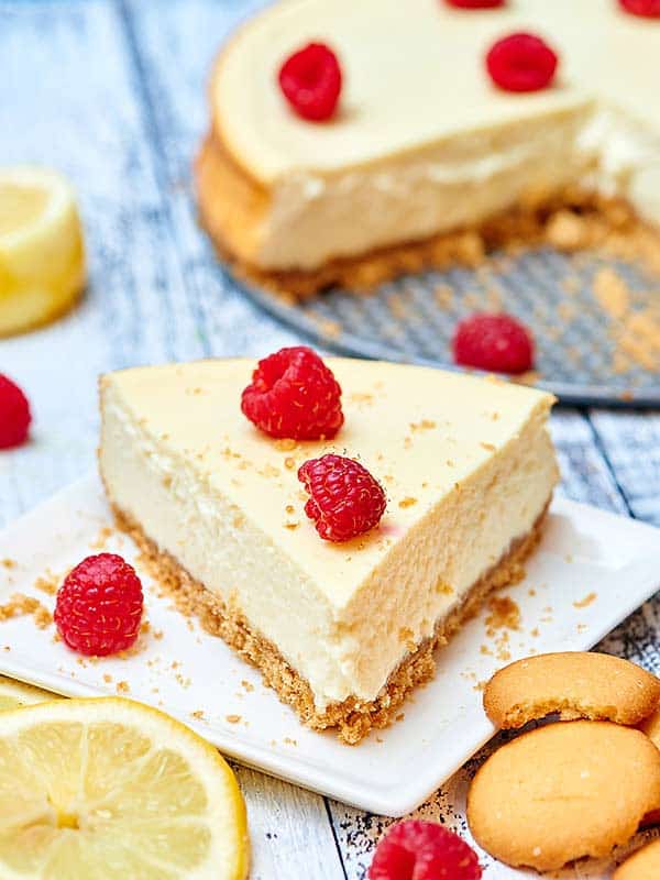 slice of cheesecake on plate with raspberries
