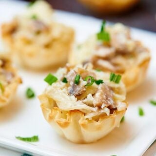 If you're looking for bite sized appetizers to serve a crowd, or just for a nice dinner at home for two, look no further because these mini caramelized onion, mushroom, and apple tarts are just a little sweet, a lot of savory, and have an amazing texture! Crunchy from the shell, and creamy and soft from the filling. The perfect bite if you ask me! showmetheyummy.com #appetizer #vegetarian #tart #appletart #oniontart #superbowl