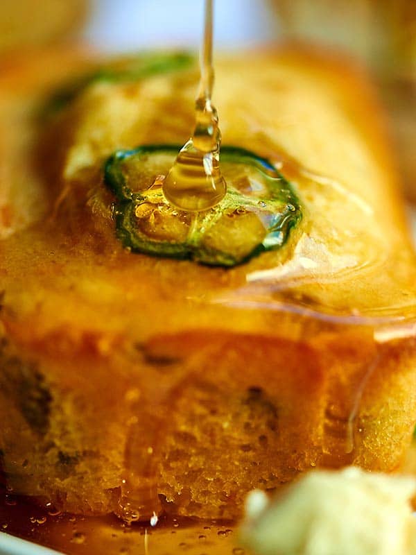 honey being drizzled over cornbread