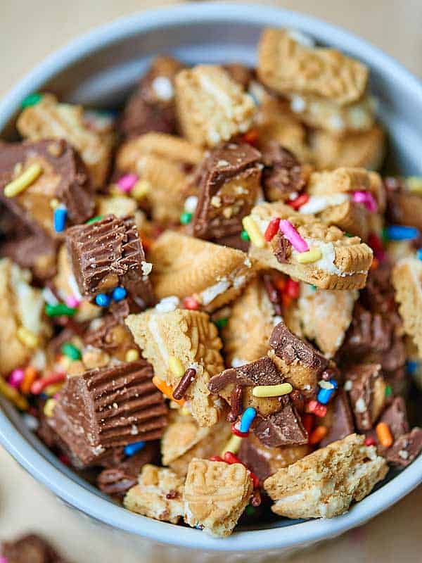 chunks of golden oreos and peanut butter cups in bowl above