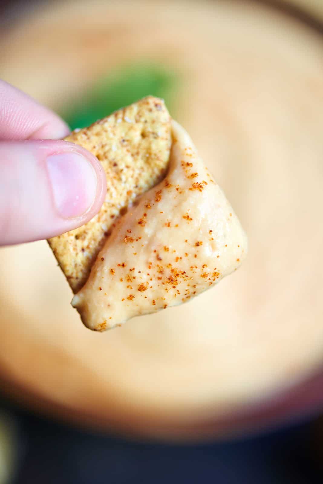 cracker with roasted red pepper hummus held