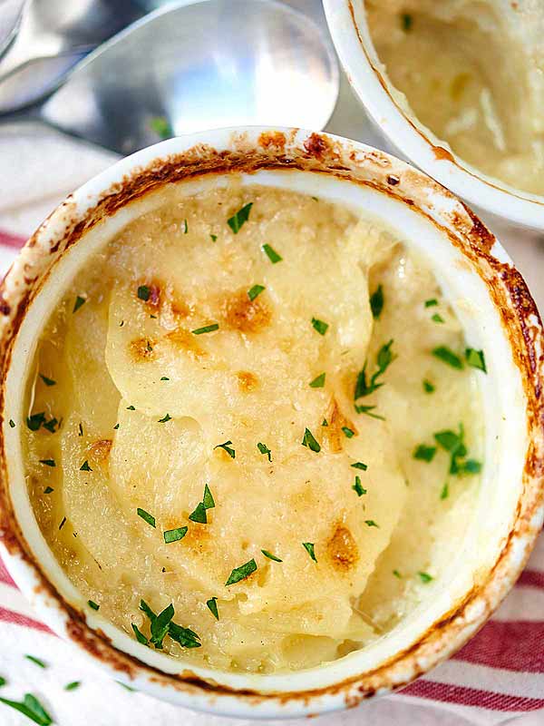 Bowl of cheesy scalloped potato gratin above