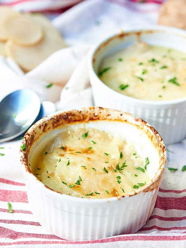 Two bowls of potato gratin, one in background