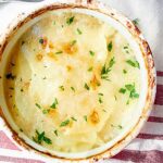 This cheesy scalloped potato gratin is simplicity at it's finest. Tender potatoes, creamy bechamel, and cheesy goodness are baked until golden brown and bubbly! showmetheyummy.com #potato #gratin #cheese #bechamel #vegetarian