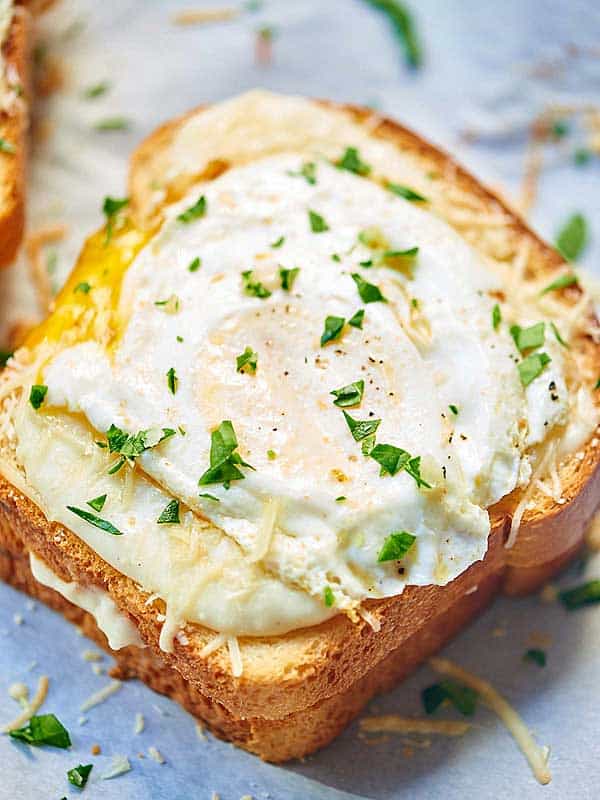 Croque Madame open faced sandwich showing egg with cilantro garnish from above