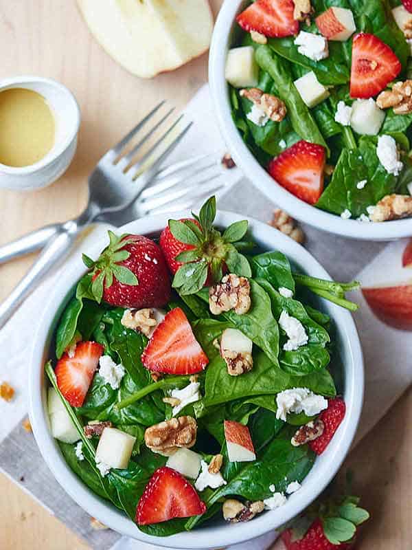 two bowls of goat cheese strawberry spinach salad above