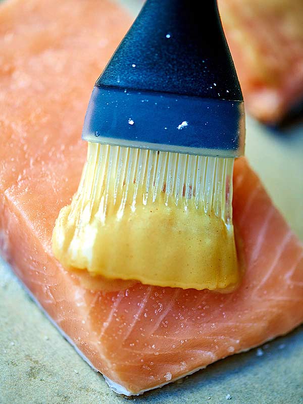 honey mustard being brushed onto salmon