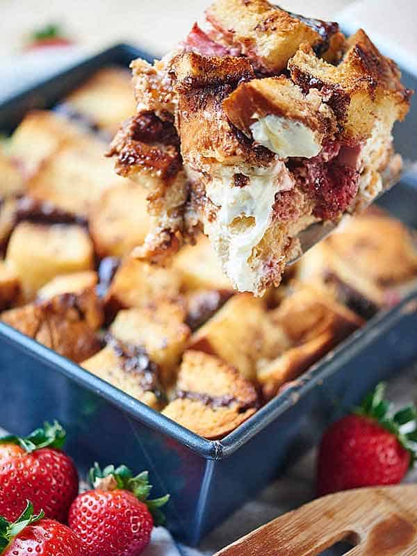 scoop of strawberry nutella cream cheese french toast casserole taken out of baking dish