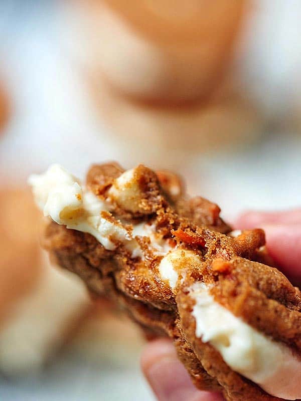 Carrot cake cookie sandwich with bite taken out held