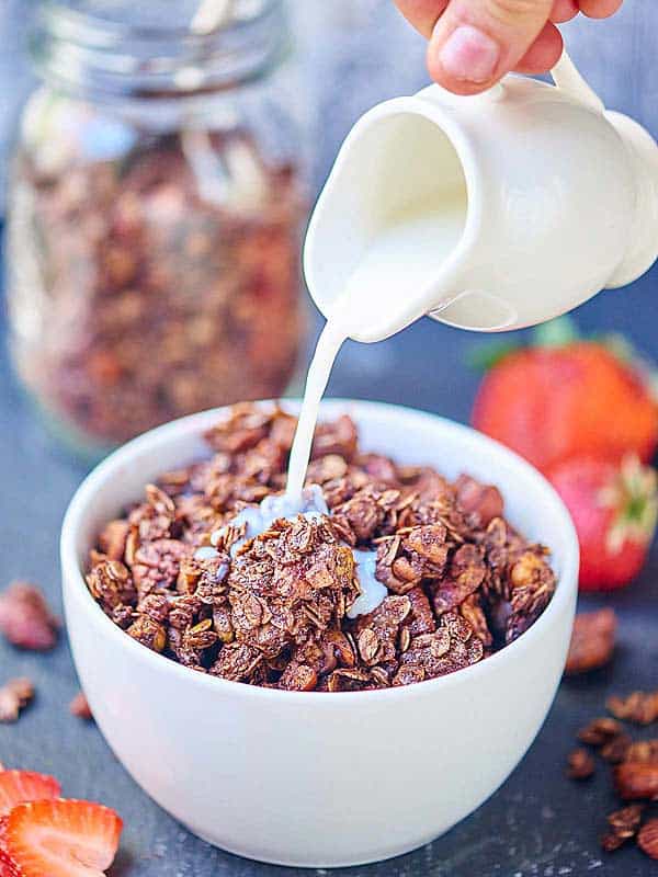 milk being poured into bowl of double chocolate granola