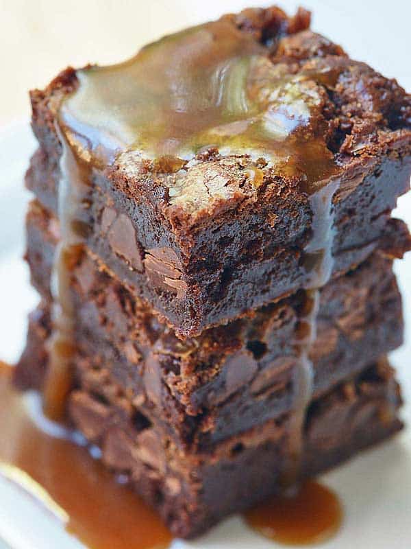3 brownies stacked drizzled with caramel sauce