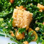 Kale Salad with Baked Almond Chicken. A healthy, protein packed salad full of massaged kale, pecorino romano cheese, golden raisins, almond chicken, and smothered in a fresh, lemony dressing! showmetheyummy.com #kale #salad #healthy #chicken #protein #lemon