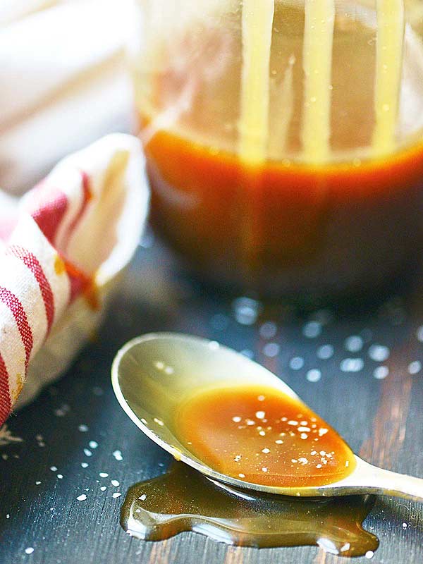 vanilla bourbon salted caramel sauce on spoon jar in background