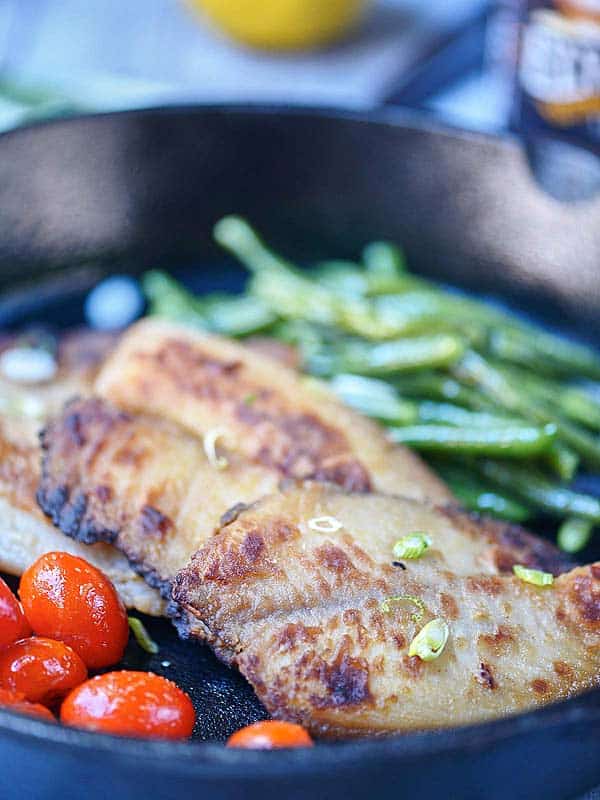 Tilapia with veggies in skillet