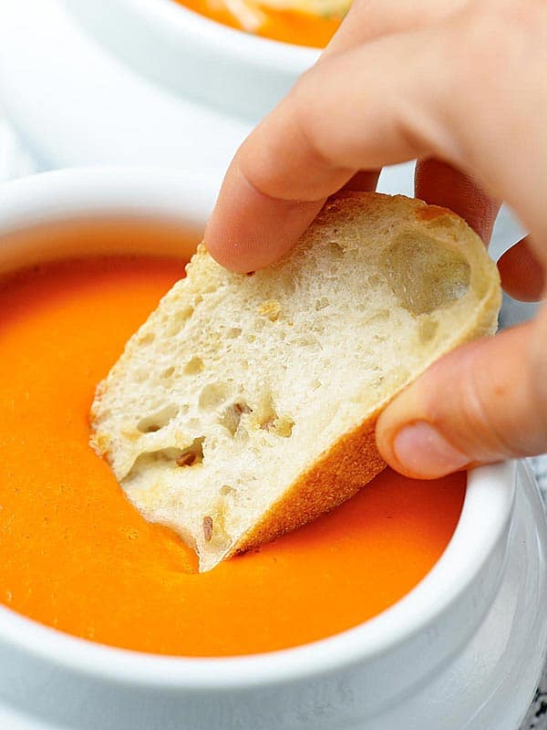 bread dipped in bowl of soup