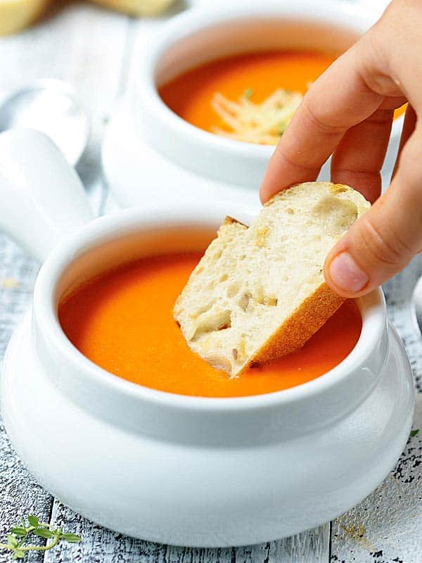 bread dipped in bowl of soup