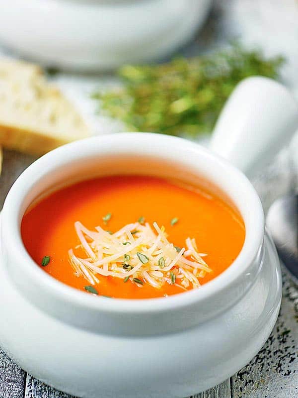 bowl of roasted red pepper soup with parmesan cheese