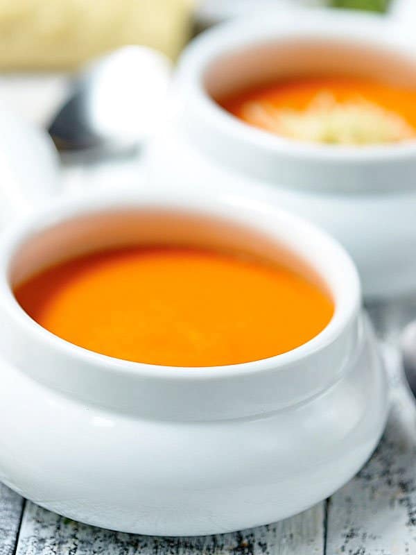 bowl of red pepper soup, another in background