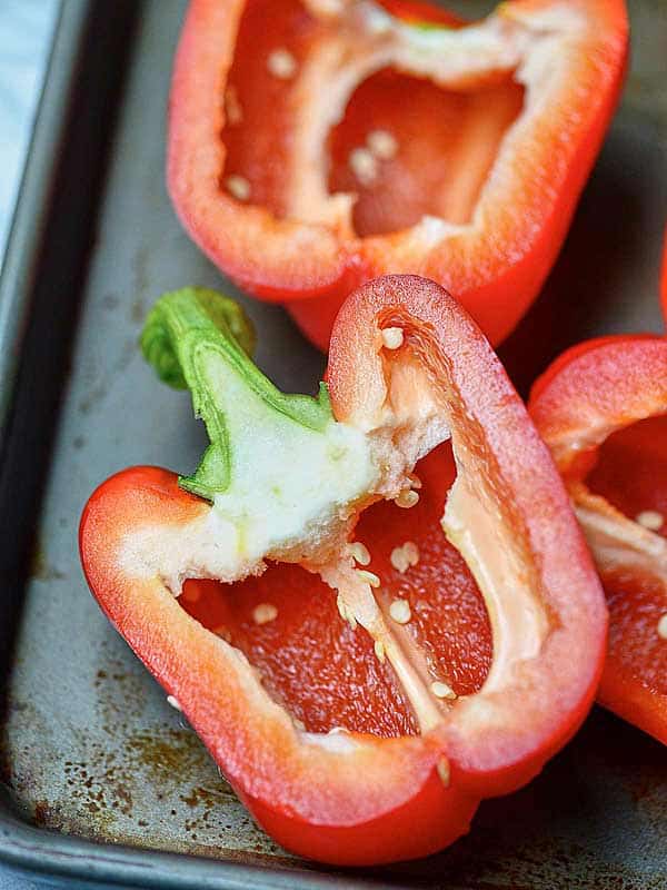 halved red peppers on baking sheet