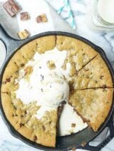 Snickers Stuffed Deep Dish Chocolate Chip Cookie. Made in a skillet, this cookie is thick, gooey, and has that great sweet/salty combo! Top it with cookie dough ice cream to take this dessert over the top! showmetheyummy.com #deepdish #cookie #snickers #candy #skillet #dessert #chocolate #icecream
