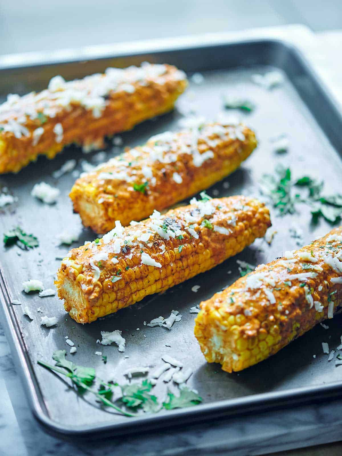 Mexican Grilled Corn. Grilled corn that’s smothered in a creamy, smoky butter and topped with salty Mexican cheese - cotija - and fresh cilantro! showmetheyummy.com #grilling #corn #mexican #cheese #butter