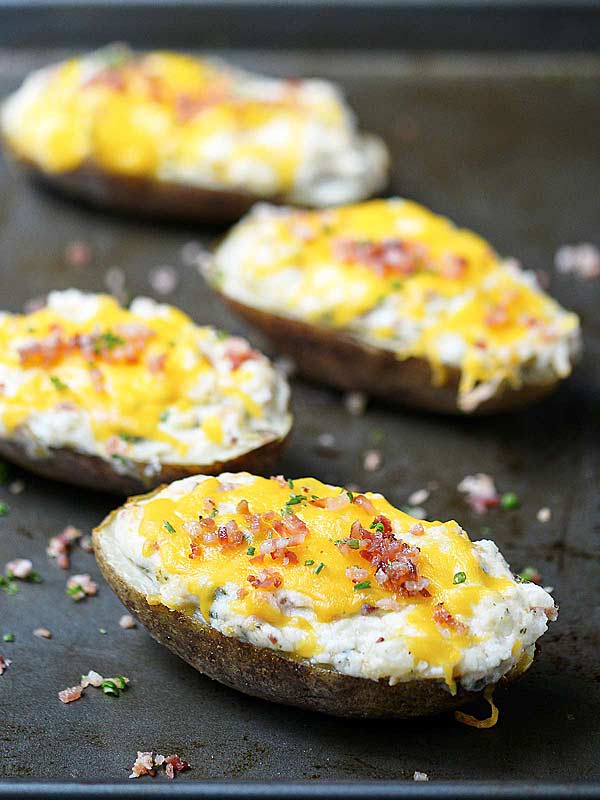 four baked potatoes lined on baking sheet