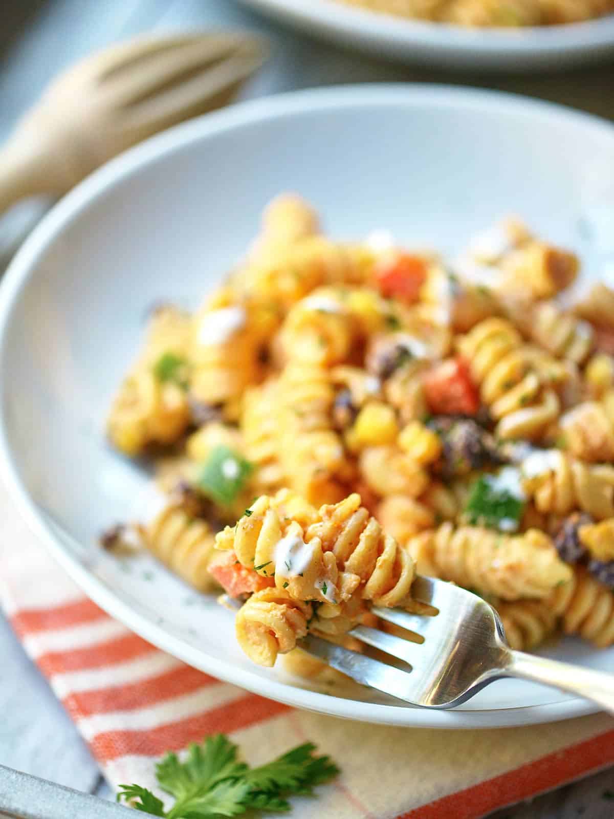 Forkful of pasta salad being taken out plate