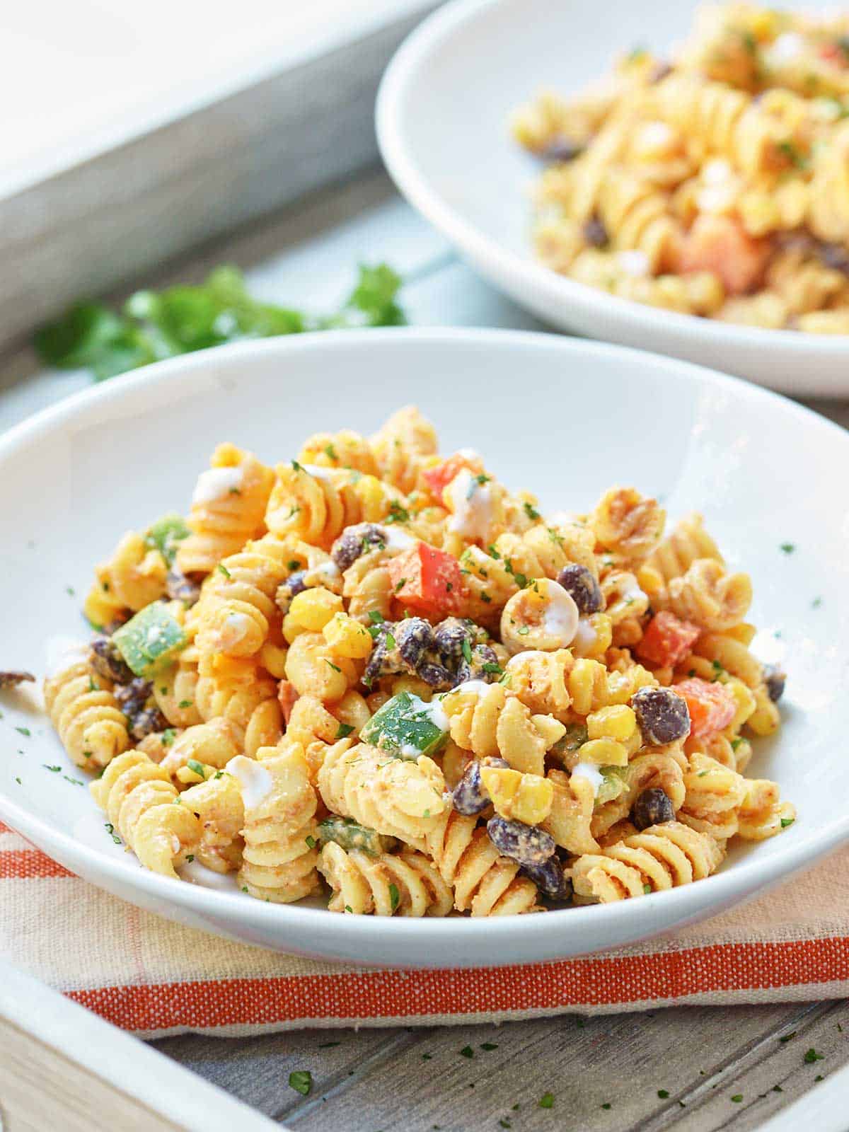 Two plates of Mexican pasta salad one in background