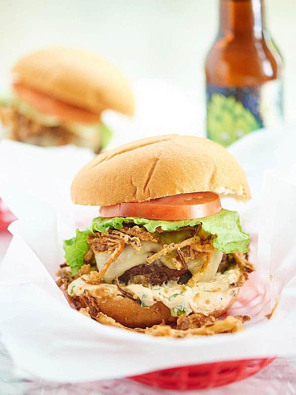 Pepper Jack Stuffed Burger with Jalapeno Cream Sauce. A juicy burger filled with gooey cheese and topped w/ a creamy jalapeno sauce and crispy fried onions! showmetheyummy.com #burger #spicy #cheese #fried #grilling