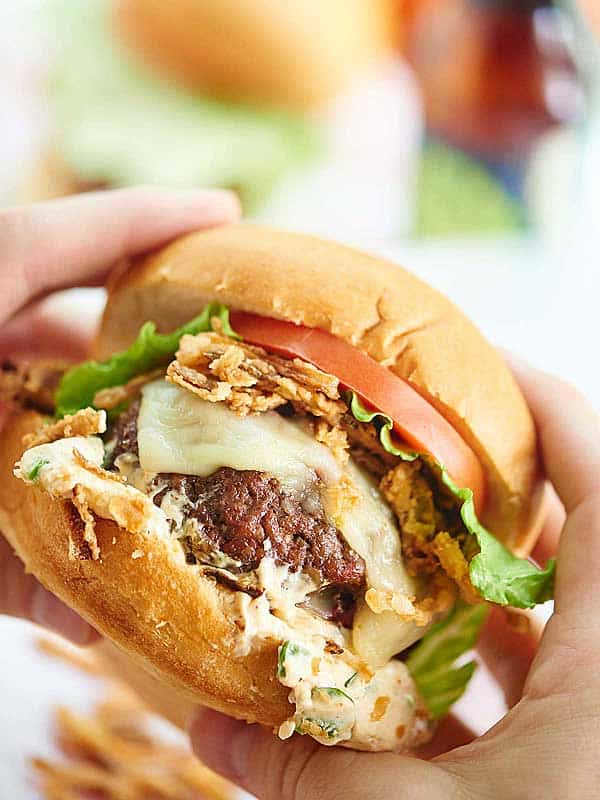 Pepper Jack Stuffed Burger with Jalapeno Cream Sauce. A juicy burger filled with gooey cheese and topped w/ a creamy jalapeno sauce and crispy fried onions! showmetheyummy.com #burger #spicy #cheese #fried #grilling
