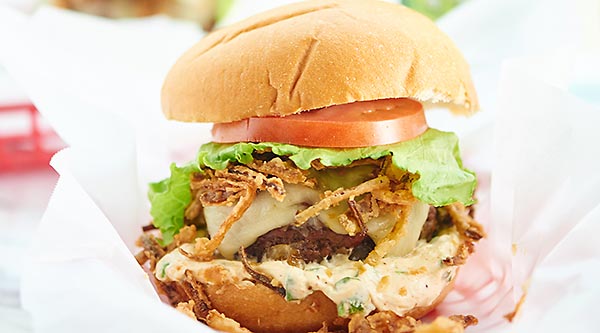 Pepper Jack Stuffed Burger with Jalapeno Cream Sauce. A juicy burger filled with gooey cheese and topped w/ a creamy jalapeno sauce and crispy fried onions! showmetheyummy.com #burger #spicy #cheese #fried #grilling