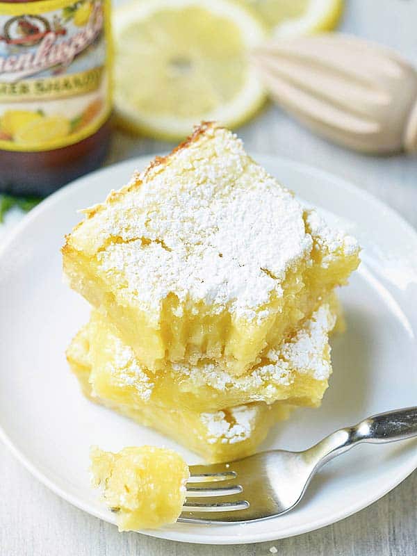 two lemon bars stacked with fork above
